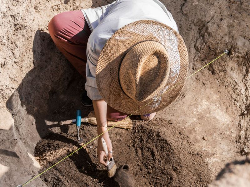 Person gräbt einen archäologischen Fund aus.