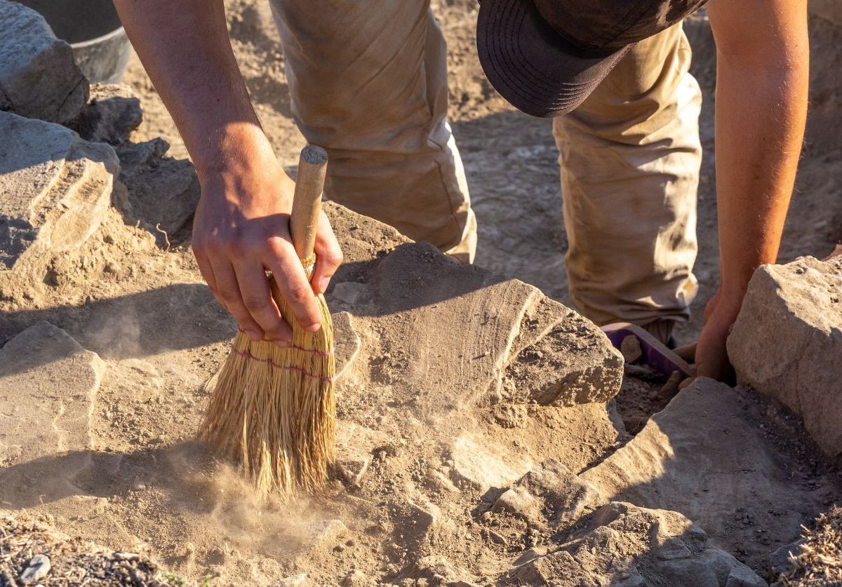 Person untersucht einen archäologischen Fund.