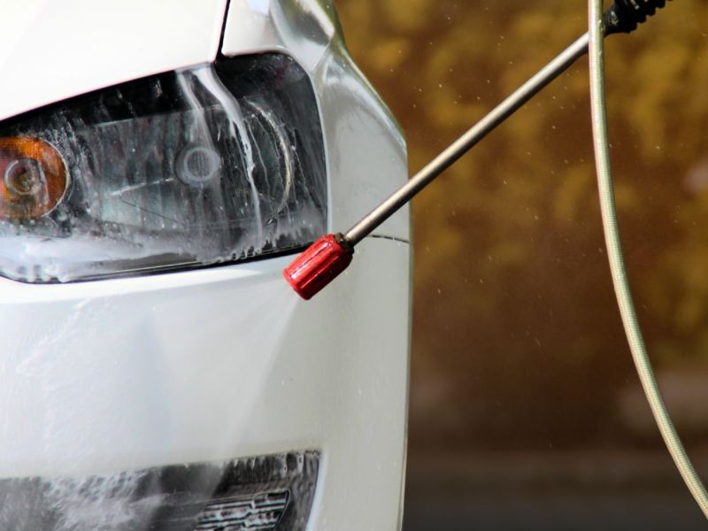 Auf ein Auto gerichteter Hochdruckreiniger