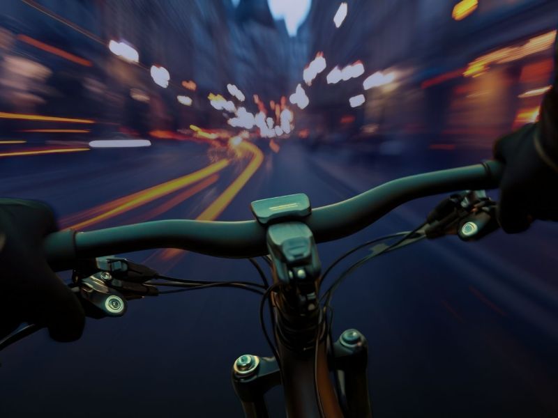 POV einer Person auf einem Fahrrad in einer abendlichen Stadt