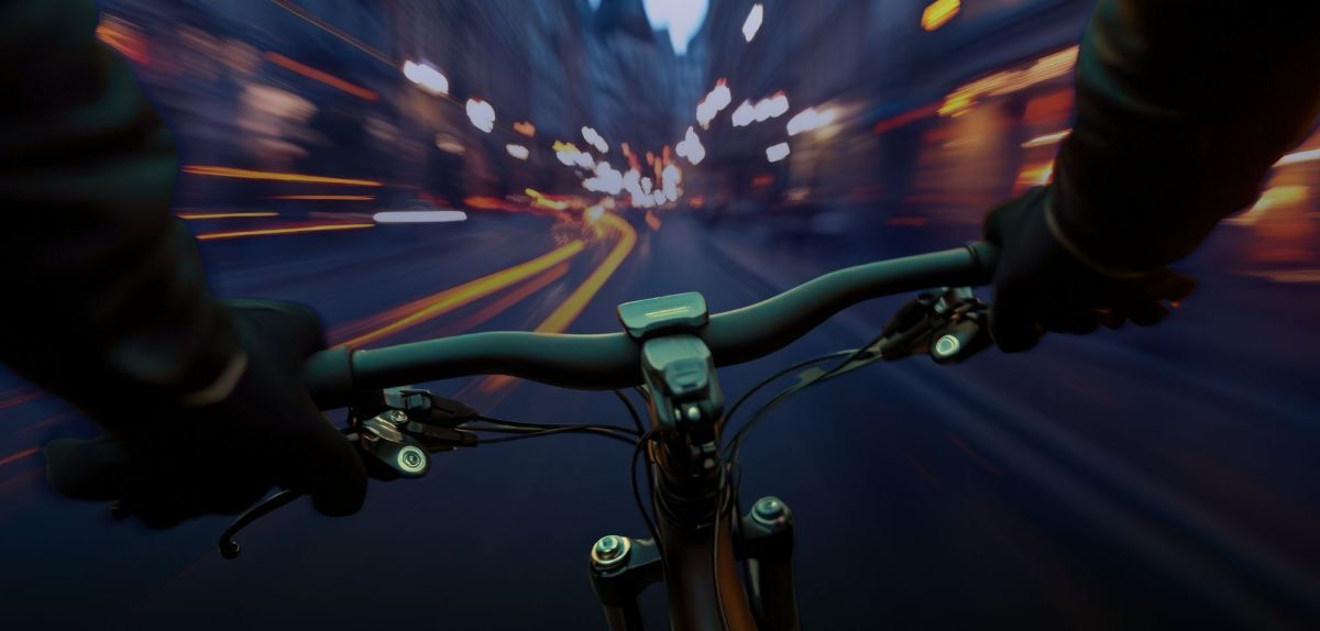 POV einer Person auf einem Fahrrad in einer abendlichen Stadt