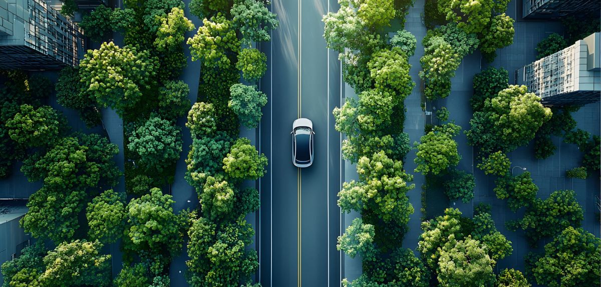 Elektroauto fährt auf einer Allee durch eine Stadt. (KI-Bild)
