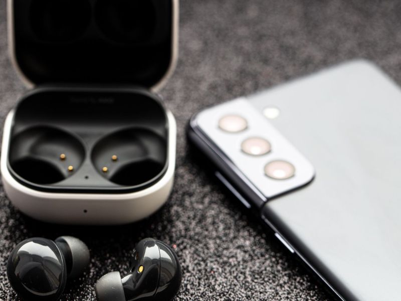 Es sind Galaxy Buds und ein Samsung Galaxy Handy zusehen.