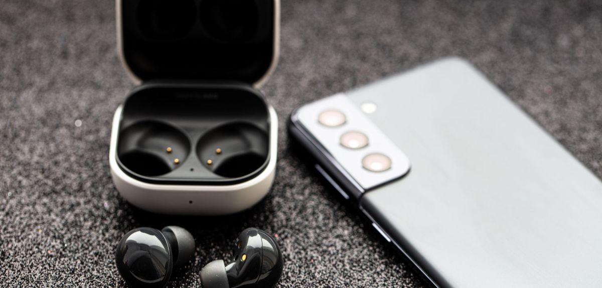 Es sind Galaxy Buds und ein Samsung Galaxy Handy zusehen.