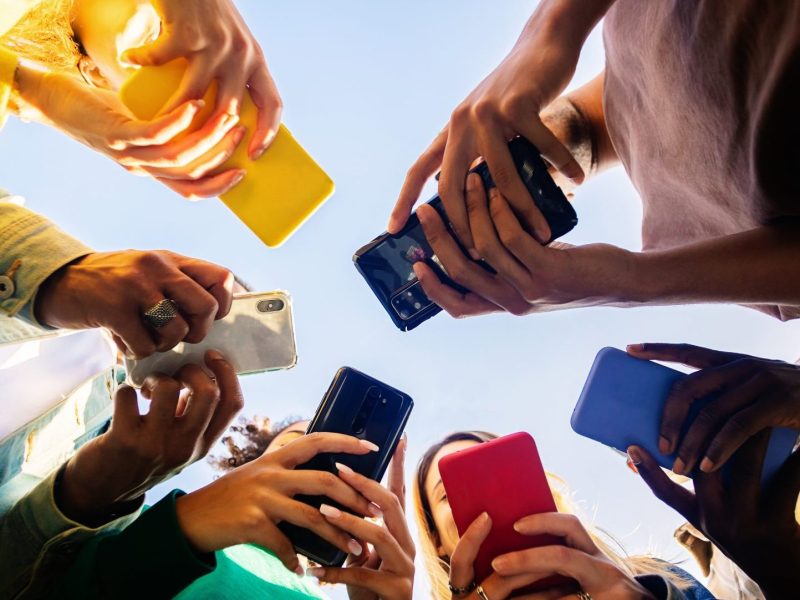 Gruppe aus Personen chattet an Handys