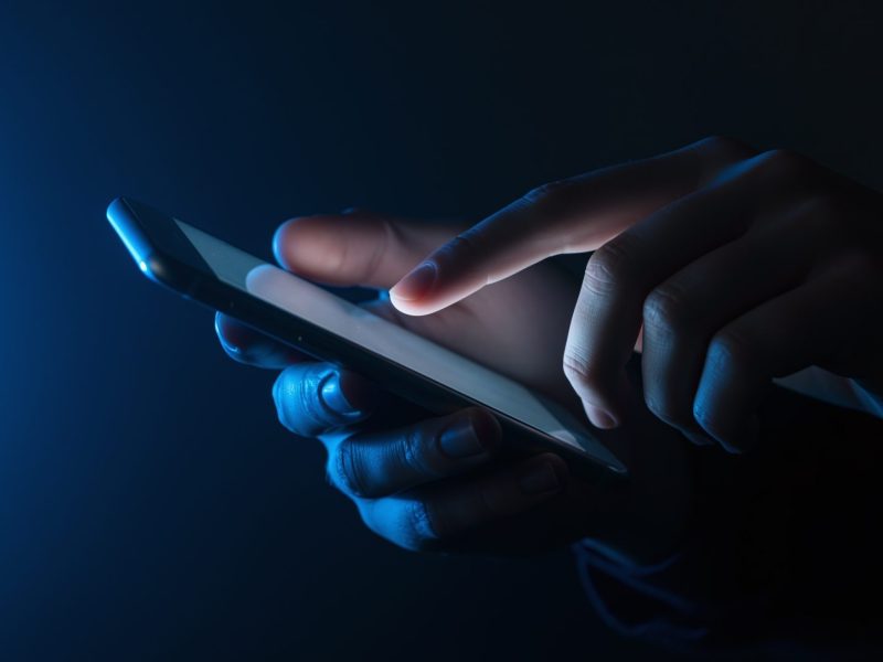 Person tippt auf ein Handy.