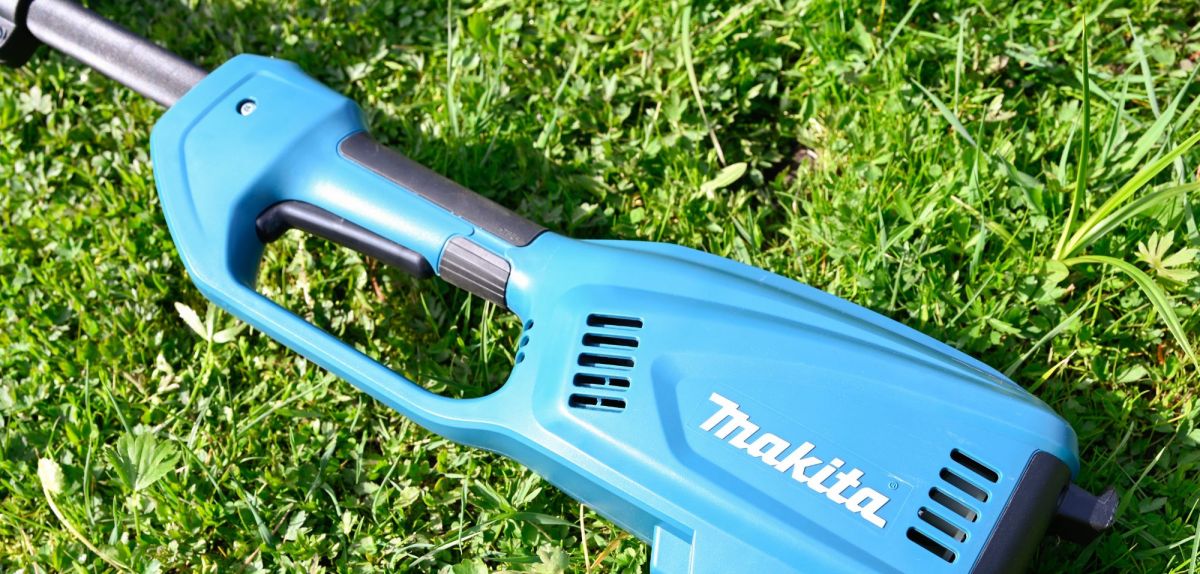 Ein Makita-Hochentaster liegt im Gras.