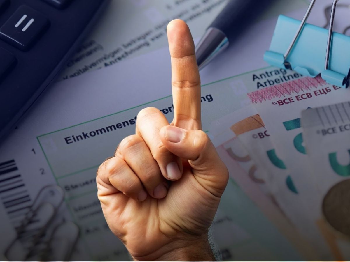 Erhobener Zeigefinger vor einer Einkommensteuererklärung