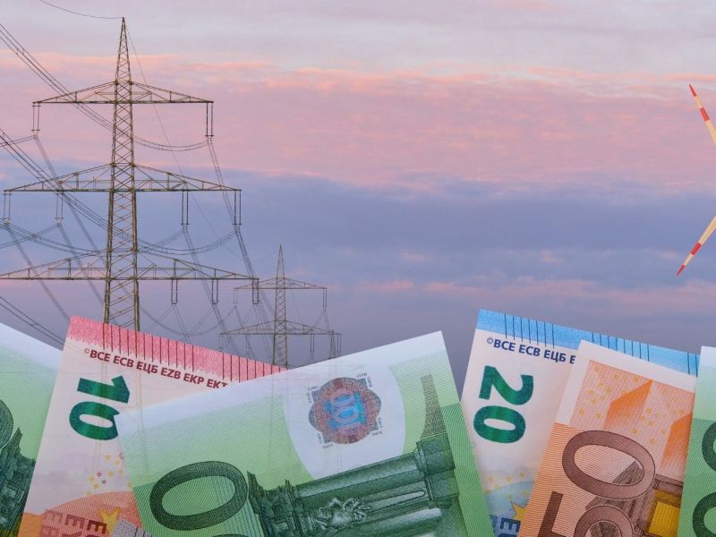 Euroscheine vor einer Stromtrasse