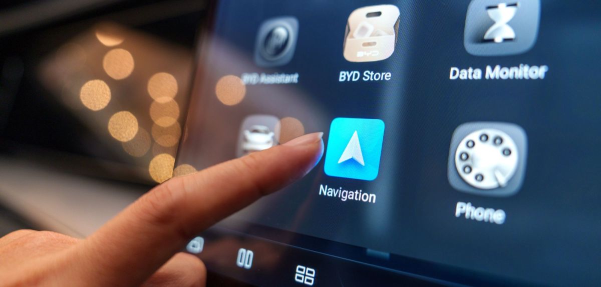 Ein Finger, der auf die Android Auto App drücken will.