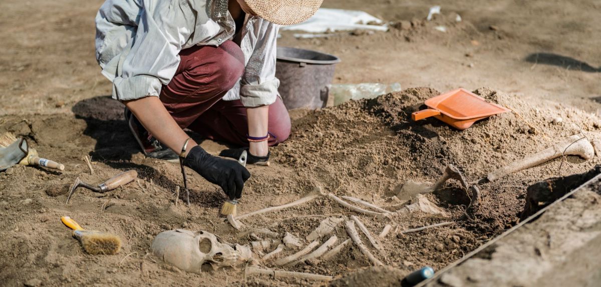 Frau untersucht einen archäologischen Fund.