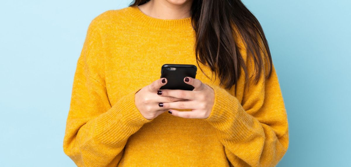 Person hält Smartphone in der Hand.
